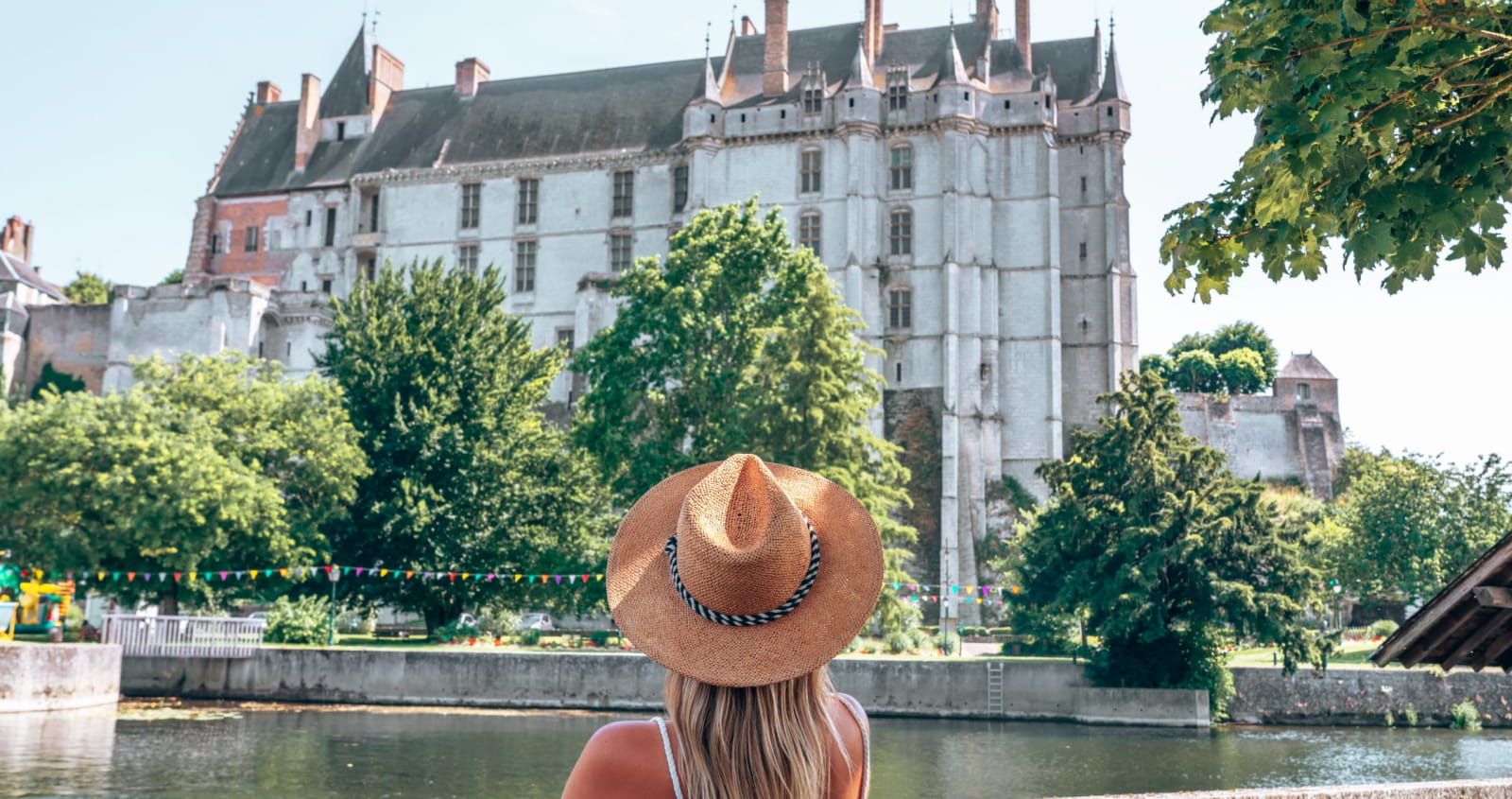 Femme assise sur un banc face au Loir et au Château de Châteaudun