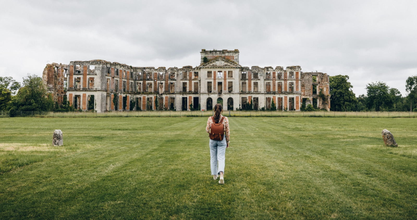 Femme face au château de La Ferté-Vidame situé en Eure-et-Loir